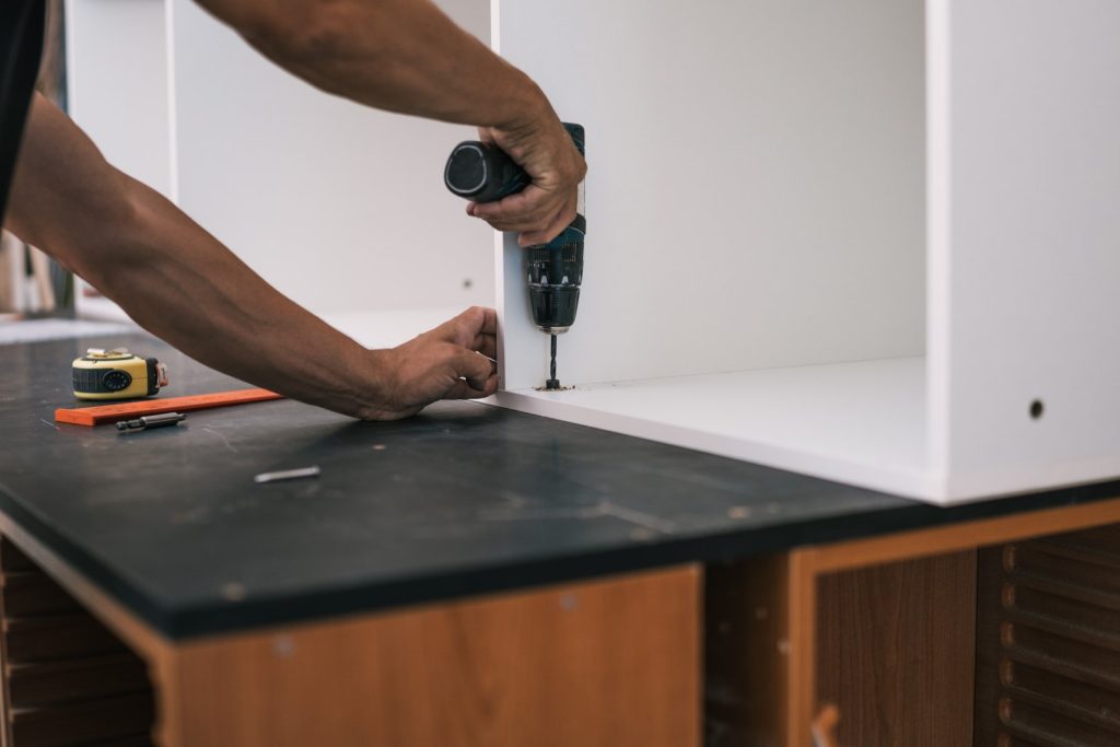 unprotected hands nailing a screw with a drill int 2026 03 09 09 21 02 utc Large Custom Cabinet Installation in Stanwood, WA Experts